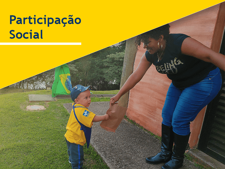 Carteiro e uma criança fantasiada com a roupa de carteiro entregam envelopes a uma mulher que segura a bandeira do Brasil. Frase do banner: Participação Social